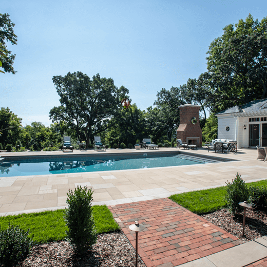 Backyard pool in the daytime with brick fireplace